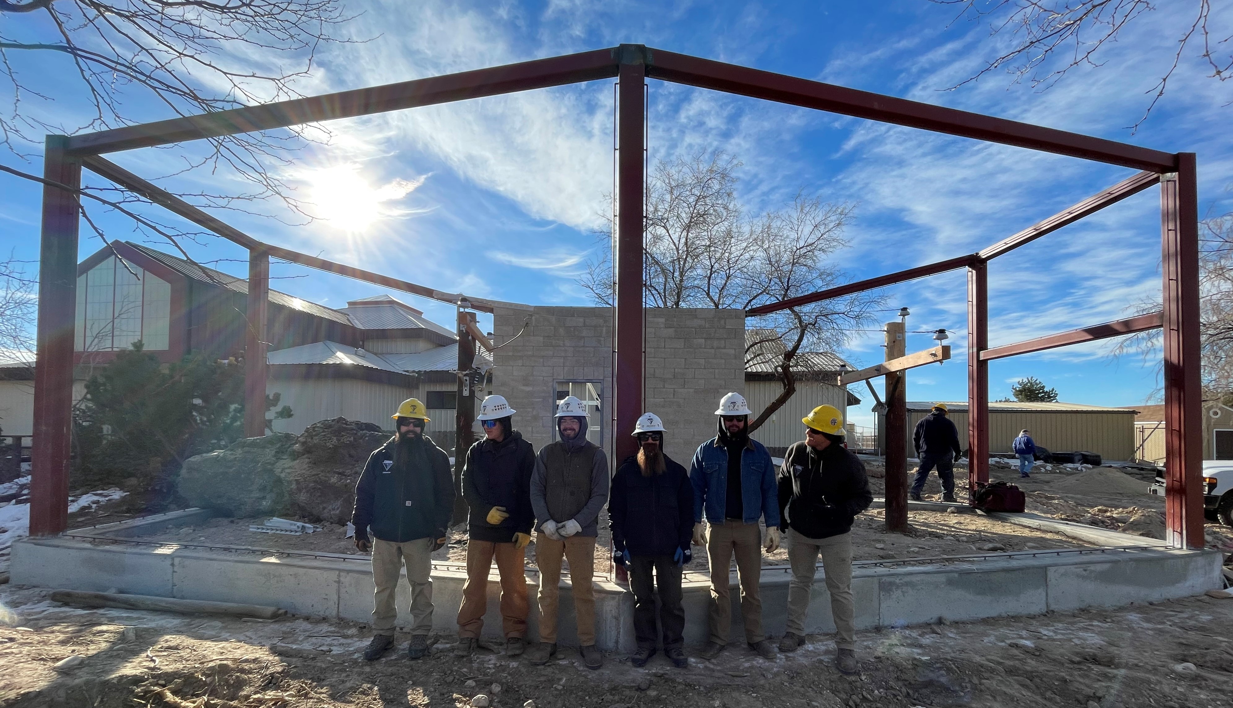 Northwest Lineman College students pose for a photo in front of the Idaho Power Flight Lab after finishing the installation of a power pole inside the new exhibit